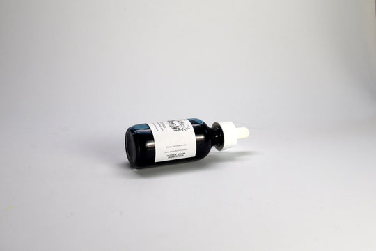 Indigo ink dropper bottle with a white label on a gray background