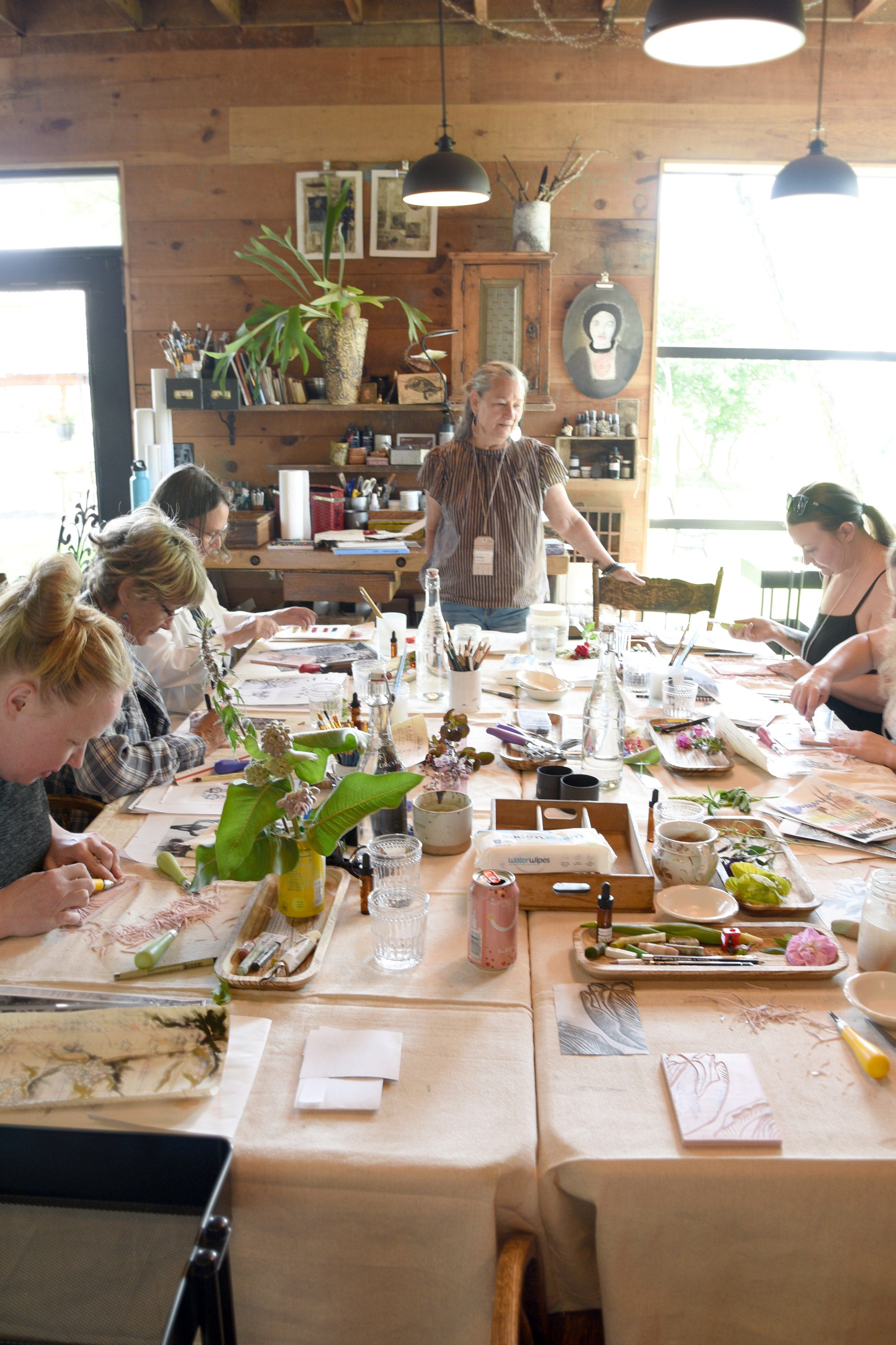 Artists at work painting and collaging in the Bee House art studio at Hunter Moon Homestead