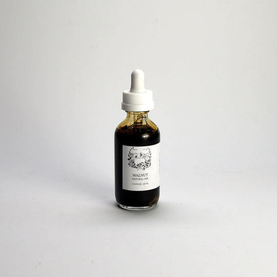 Bottle of walnut artists ink with a dropper on a white background