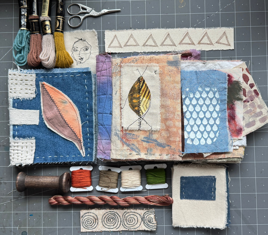 Textile art project with fabric samples and embroidery tools on a grid background