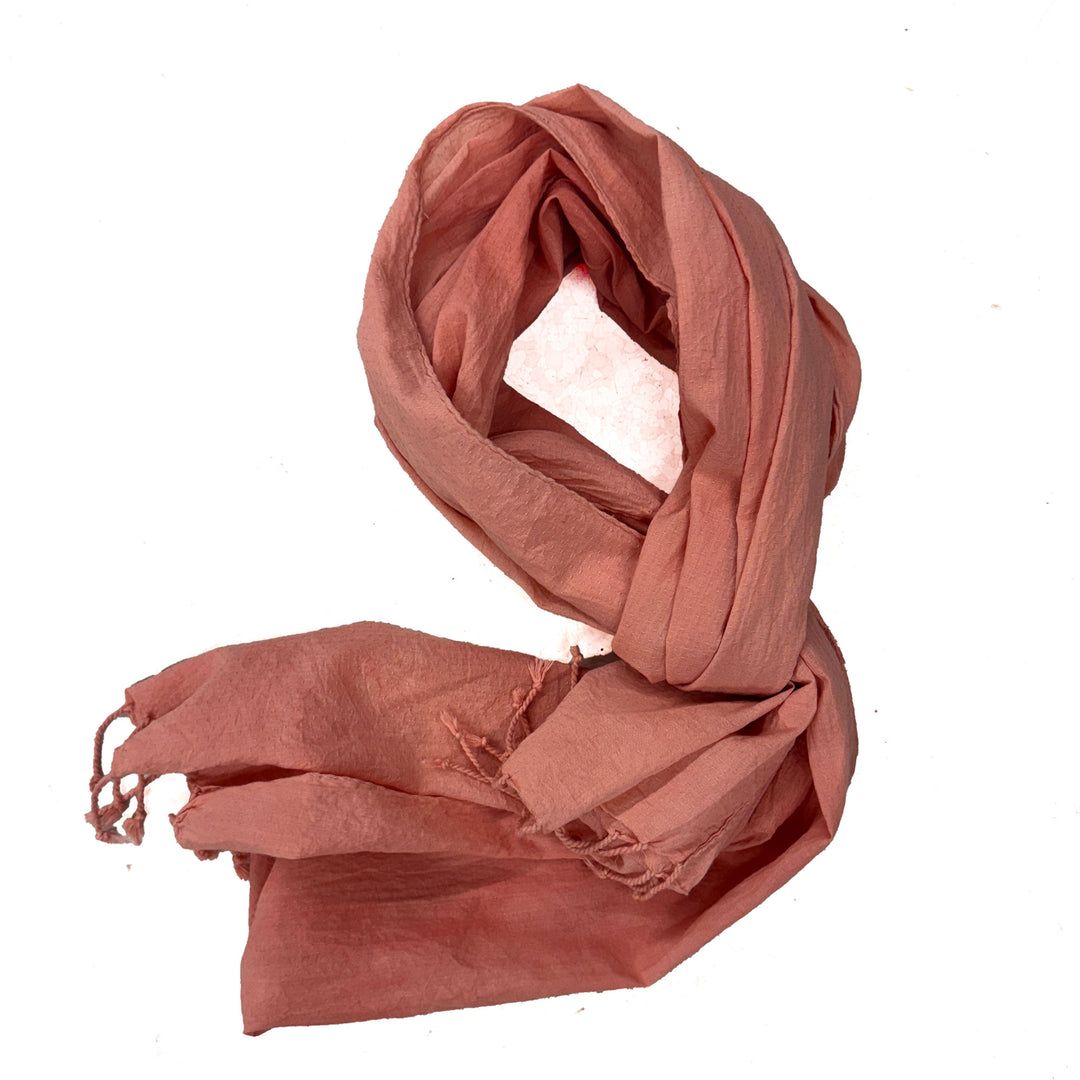 Pink cotton scarf with frayed edges on a white background