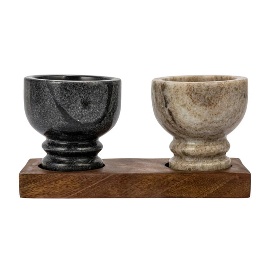 Two marble egg cups on a wooden stand against a white background